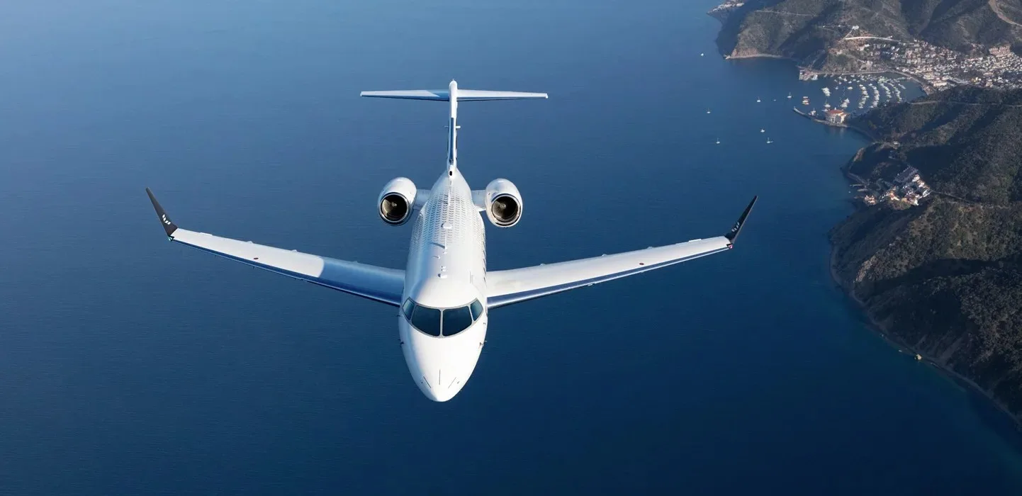 Business jet in flight above a coastline