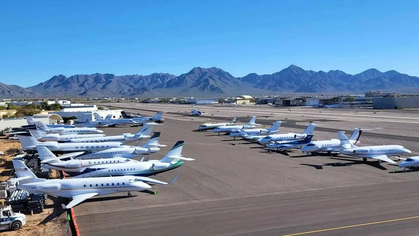 Business jets parked on the ramp outside a private terminal