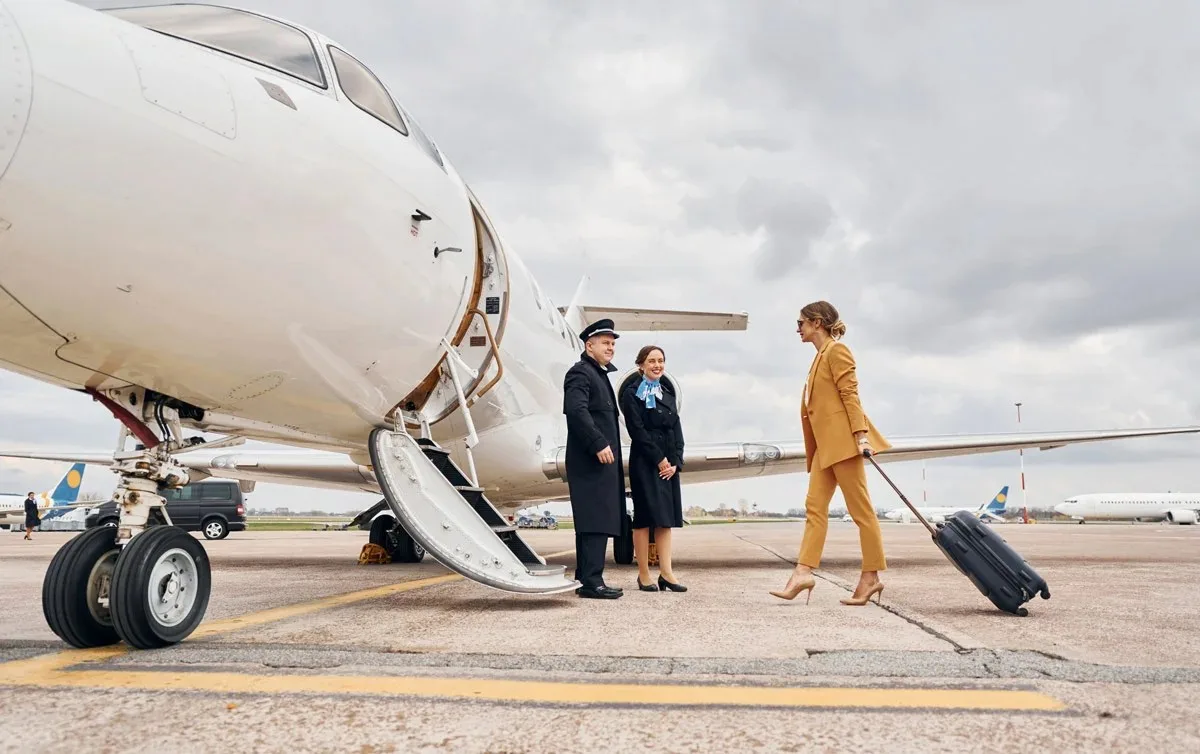 Passengers walking across the ramp to a private jet with the crew